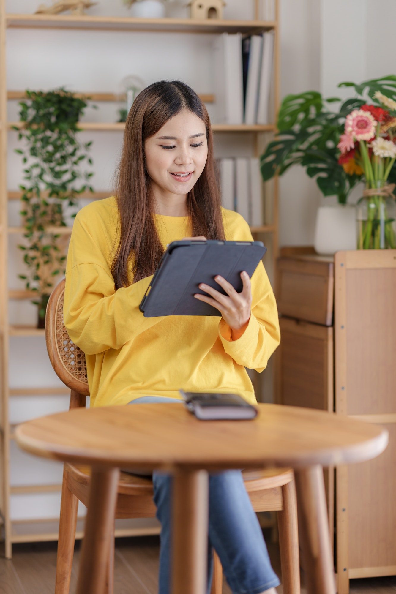 Beautiful asian business woman working at home using digital tablet with peace of mind