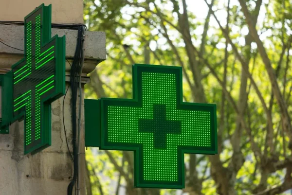 Deux croix vertes à LED fixées perpendiculairement à une façade