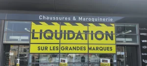 Grand adhésif jaune Liquidation sur la vitrine du magasin de chaussures
