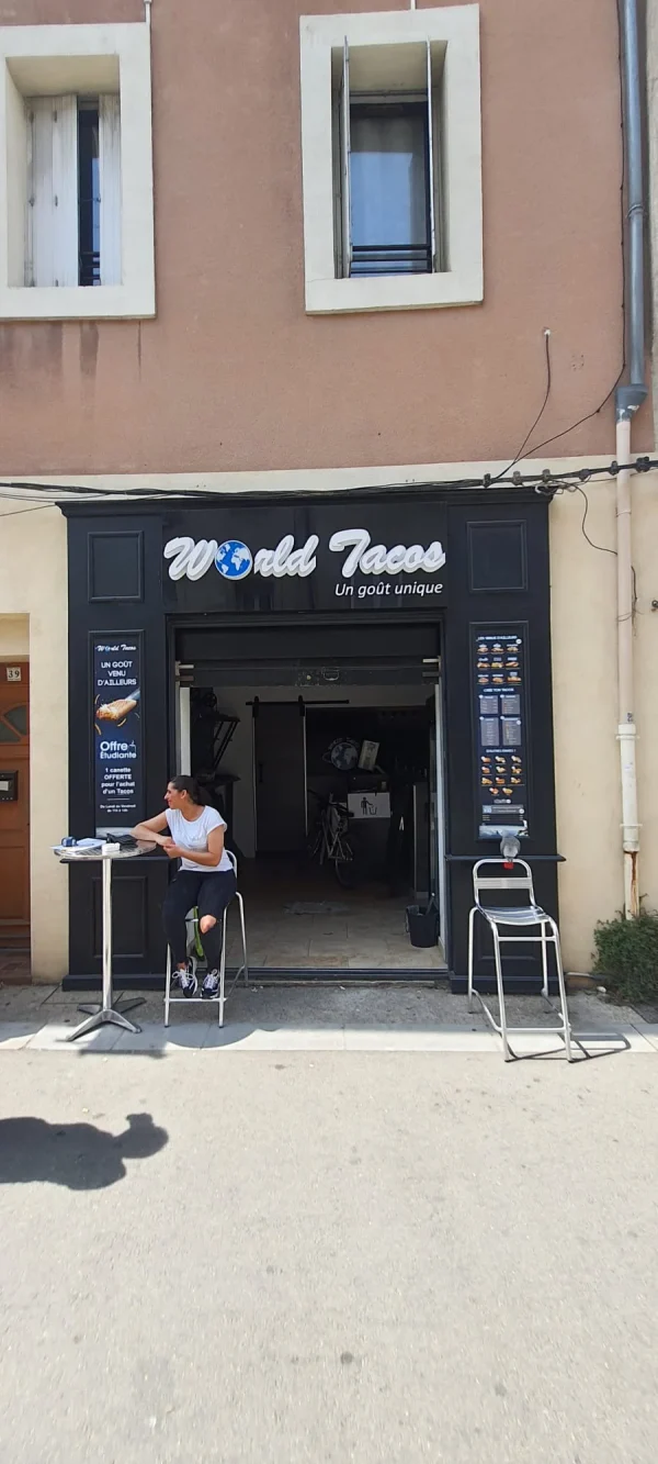 Devanture noire World Tacos avec lettres blanches, panneaux menus et terrasse extérieure
