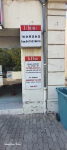 Caisson La Tribune avec téléphone et fax au-dessus d’un panneau petites annonces et publicité