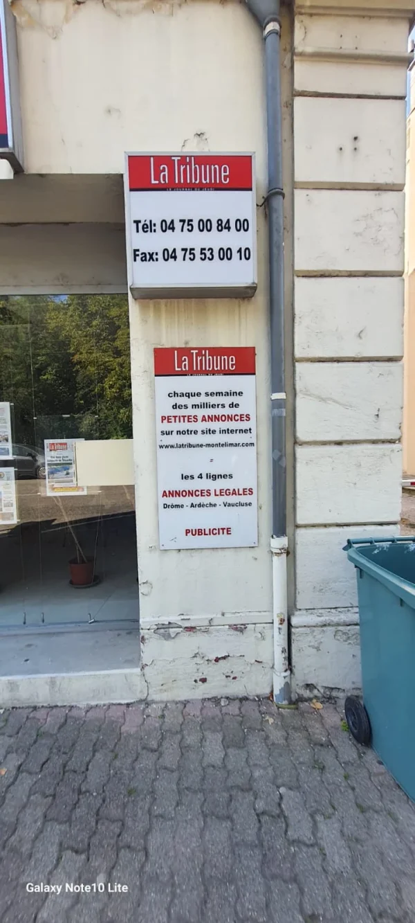 Caisson La Tribune avec téléphone et fax au-dessus d’un panneau petites annonces et publicité