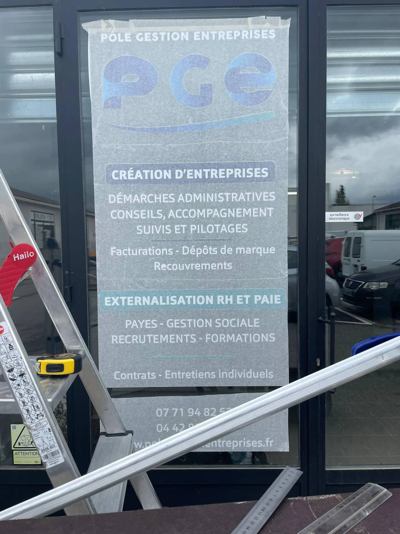 Enseigne lettres découpées et adhésifs lettrage poset et depose blanc visible sur la photographie