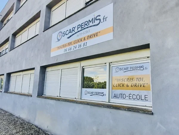 Vue latérale de la façade Oscar Permis avec enseigne haute et vitrophanie auto-école