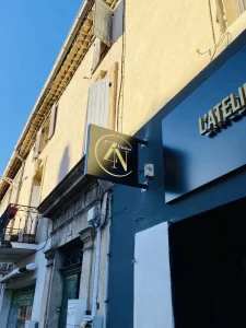 Caisson drapeau noir et doré L’Atelier ZN sur façade