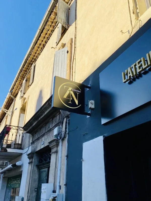 Caisson drapeau noir et doré L’Atelier ZN sur façade