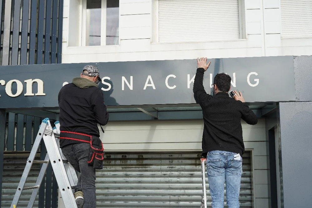 Poseur devant le lettrage du Luberon – habillage vitrine adhésif paris