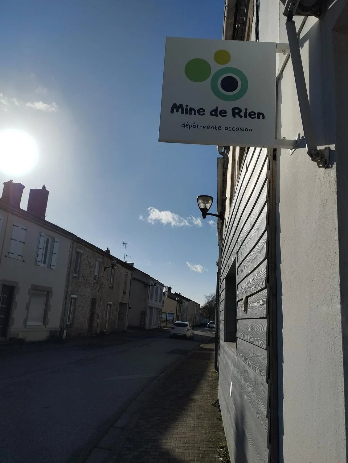 Caisson drapeau blanc Mine de Rien au-dessus d’une rue