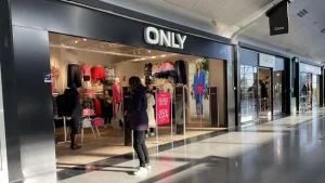 Lettrage Only blanc sur bandeau noir à l’entrée d’une boutique de vêtements