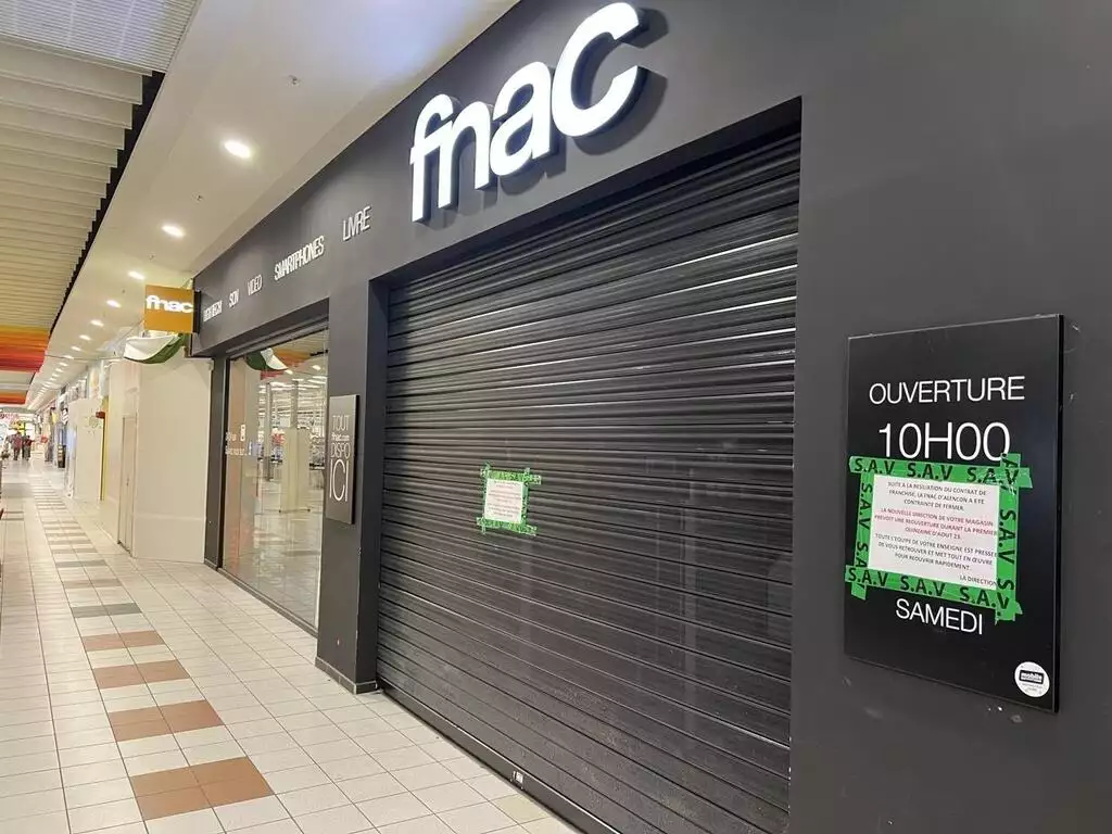 Logo Fnac lumineux au-dessus du rideau métallique d’un magasin