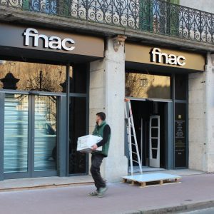 Deux logos Fnac en lettres relief au-dessus de portes vitrées