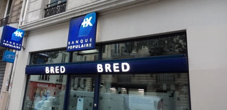 Bandeau bleu BRED et enseignes drapeau Banque Populaire sur une agence