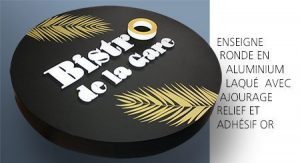 Enseigne ronde noire avec lettres blanches et décor doré en relief