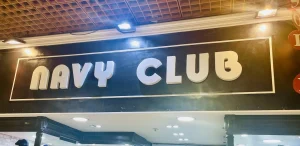 Enseigne lumineuse Navy Club sur bandeau noir