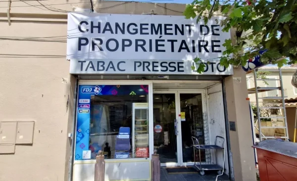 Panneau changement de propriétaire sur la façade d'un tabac presse
