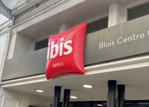 Enseigne drapeau rouge Ibis sur façade d'hôtel