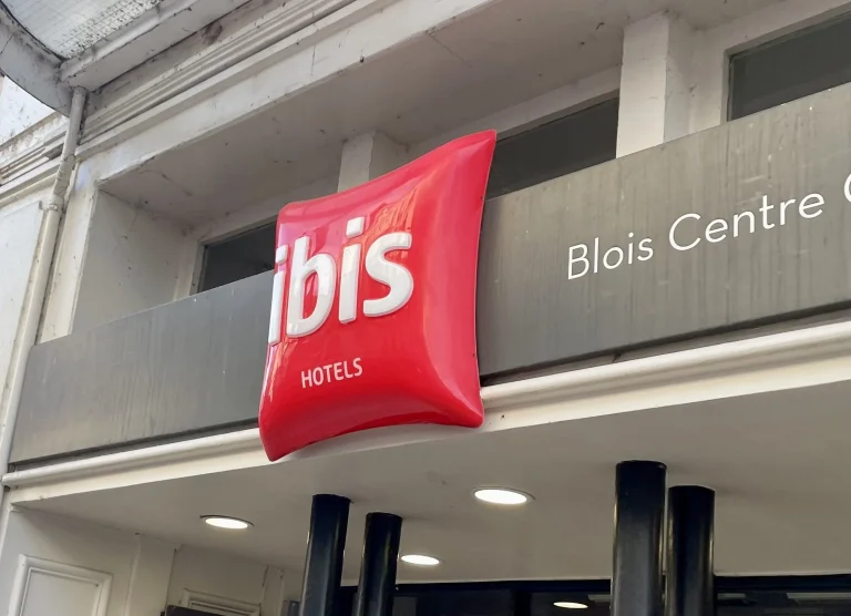 Enseigne drapeau rouge Ibis sur façade d'hôtel