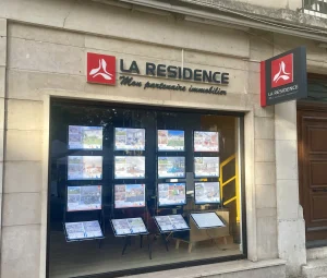 Vitrine d'agence immobilière La Résidence avec enseigne