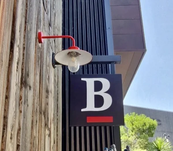 Enseigne drapeau carrée avec lettre B sur bardage bois