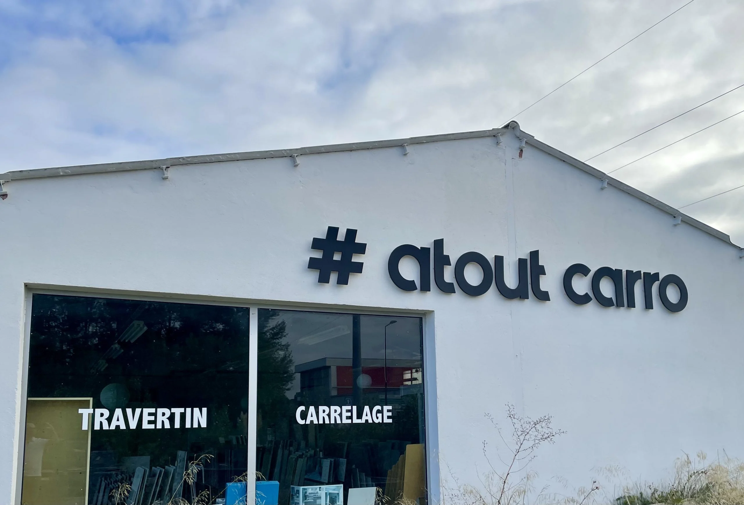 Lettres en relief Atout Carro sur façade blanche