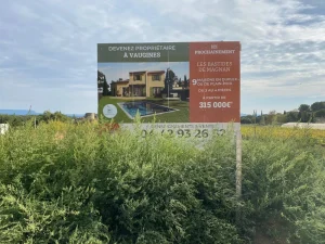 Panneau de promotion immobilière au milieu de la végétation