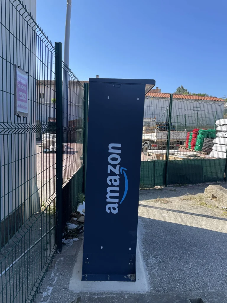 Exemple de réalisation Premium Enseigne – borne de recharge amazon près d’un parking clôturé