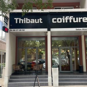 Façade d’un salon de coiffure nommé Thibaut Coiffure, avec enseigne et entrée vitrée