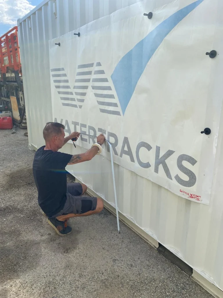 Pose d'une bâche imprimée Watertracks sur un conteneur maritime