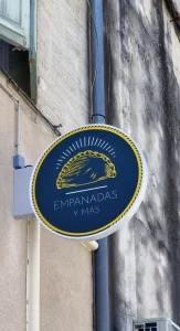 Enseigne ronde « Empanadas y más » avec un empanada stylisé