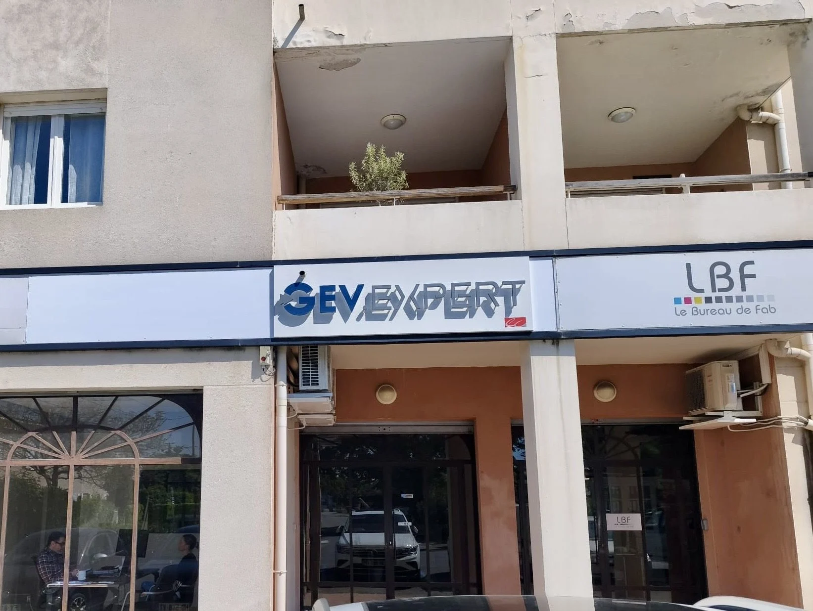 Enseigne en lettres découpées GEV Expert posée sur façade d'immeuble