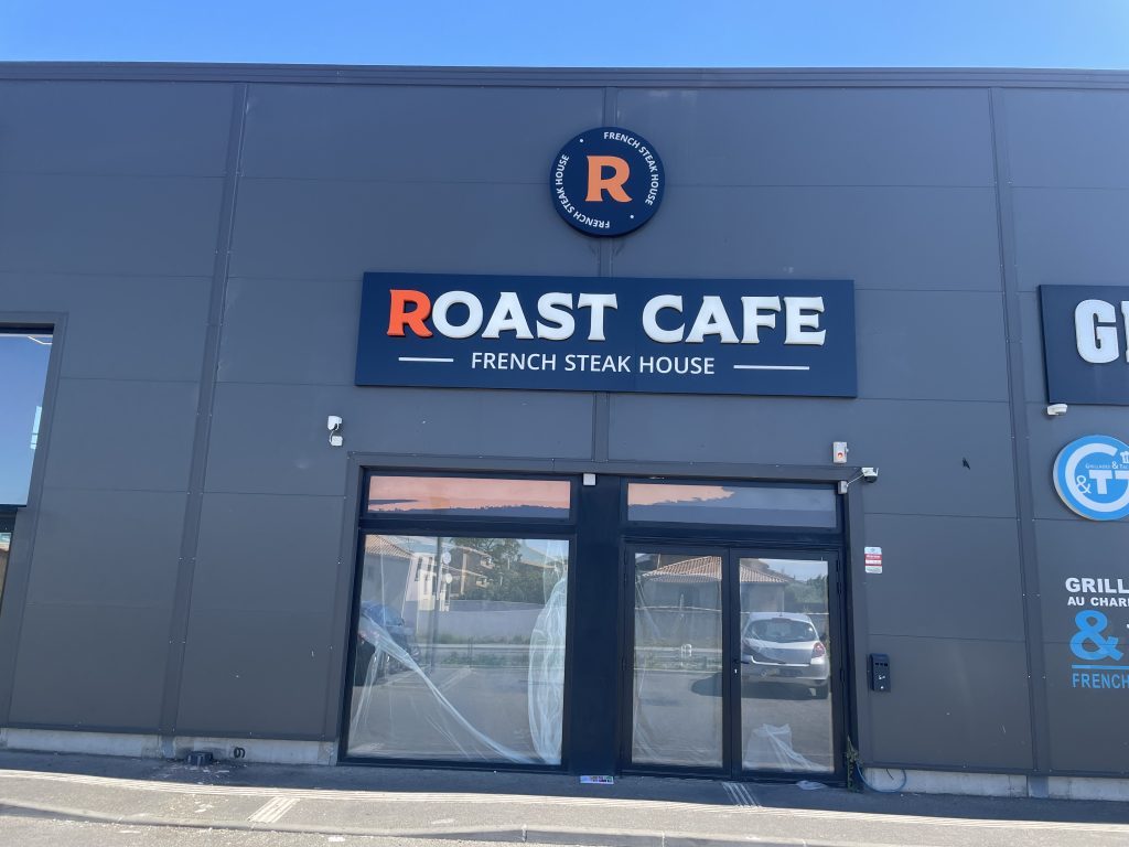 Façade commerciale Roast café à Avignon avec enseigne 'Roast Cafe' sur tablette au-dessus de la vitrine